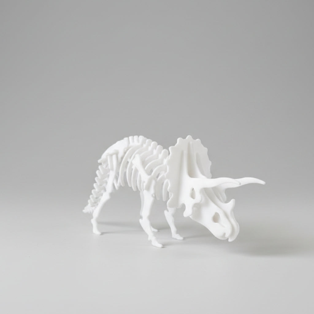 A white 3D-printed articulated dinosaur skeleton model, specifically a Triceratops, shown on a neutral light gray background.