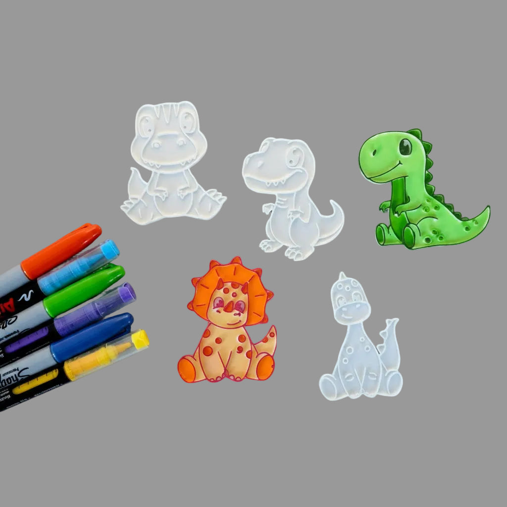 Five dinosaur-shaped stamps on a wooden surface with markers.