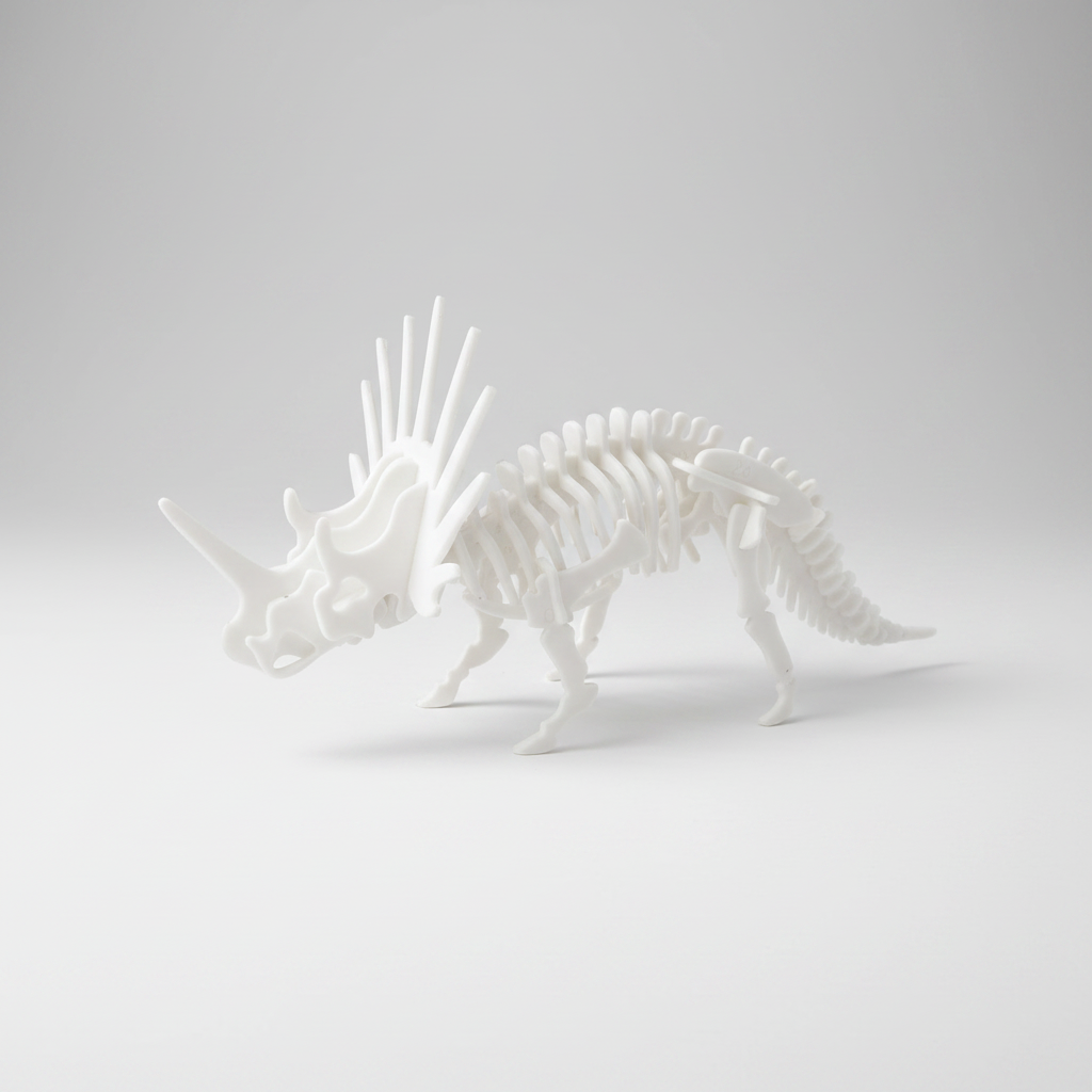 A white 3D-printed articulated Styracosaurus dinosaur skeleton model, shown from a side profile on a clean white background.