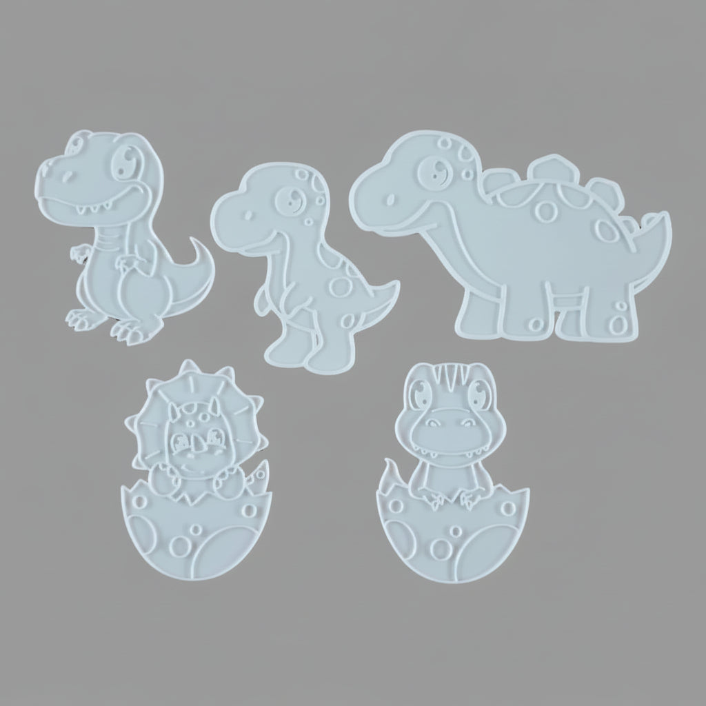 Five white dinosaur-shaped stencils arranged on a gray background, including a T-Rex, a Stegosaurus, an egg-shaped dinosaur, and two dinosaur hatching figures.
